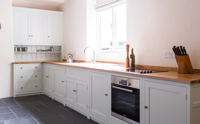Shaker style kitchen. Birch plywood cabinets with hand painted hardwood frames (Farrow and Ball Estate Eggshell, Pale Powder).Traditional inset sink and integral dishwasher. Inset cooker hob and integral oven. 4.5m full stave oak worktop with upstand. Solid brass hinges and adjustable brass shelf supports. Solid oak dovetailed drawers with painted hardwood fronts. Hand turned beech knobs. Shaker style kitchen. Birch plywood cabinets with hand painted hardwood frames (Farrow and Ball Estate Eggshell, Pale Powder).Traditional inset sink and integral dishwasher. Inset cooker hob and integral oven. 4.5m full stave oak worktop with upstand. Solid brass hinges and adjustable brass shelf supports. Solid oak dovetailed drawers with painted hardwood fronts. Hand turned beech knobs.