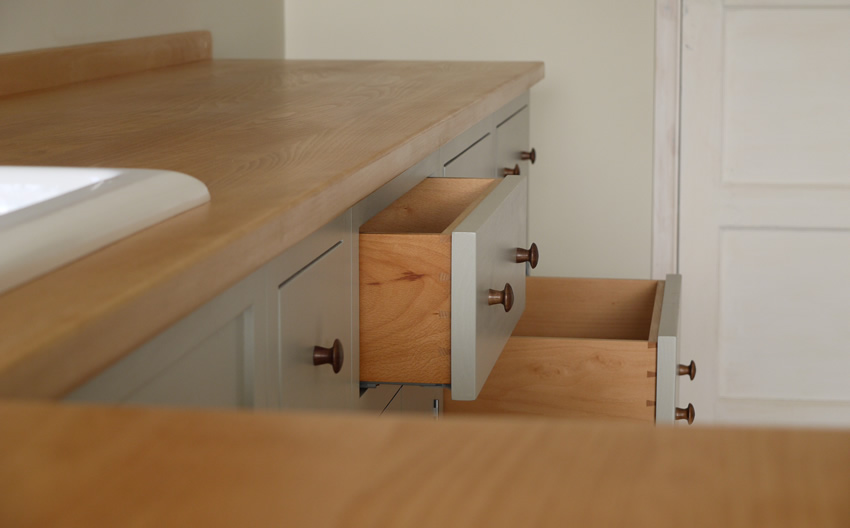 Shaker style kitchen. Birch plywood cabinets with hand painted hardwood frames (Farrow and Ball, Lamp Room Gray). Sink area with integral dishwasher, traditional ceramic inset sink and full stave beech top and upstand. Dovetailed drawers made of solid beech with painted hardwood fronts and walnut hand turned knobs.