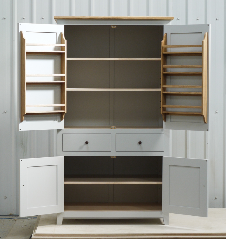Larder cupboard handpainted in Farrow & Ball Estate Egshell - 'Pavilion Gray'. Tulip wood carcass with painted birch ply panels and maple faced birch ply shelves. Dovetailed oak drawers on high quality soft close runners. Oak spice racks. High quality solid brass hinges and adjustable brass shelf supports. Solid oak cornice and walnut knobs.