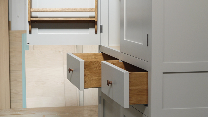 Larder cupboard handpainted in Farrow & Ball Estate Egshell - 'Pavilion Gray'. Tulip wood carcass with painted birch ply panels and maple faced birch ply shelves. Dovetailed oak drawers on high quality soft close runners. Oak spice racks. High quality solid brass hinges and adjustable brass shelf supports. Solid oak cornice and walnut knobs.