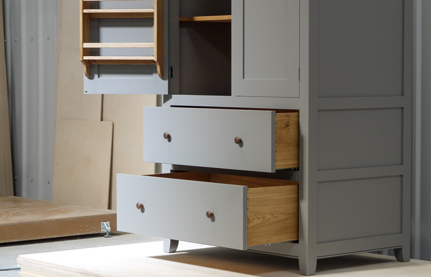 Larder cupboard handpainted in Farrow & Ball Estate Egshell - 'Mole's Breath'. Tulip wood carcass with birch ply panels and shelves. Dovetailed oak drawers on high quality soft close runners. Oak spice racks. Solid brass hinges and adjustable brass shelf supports. Solid walnut cornice and knobs.