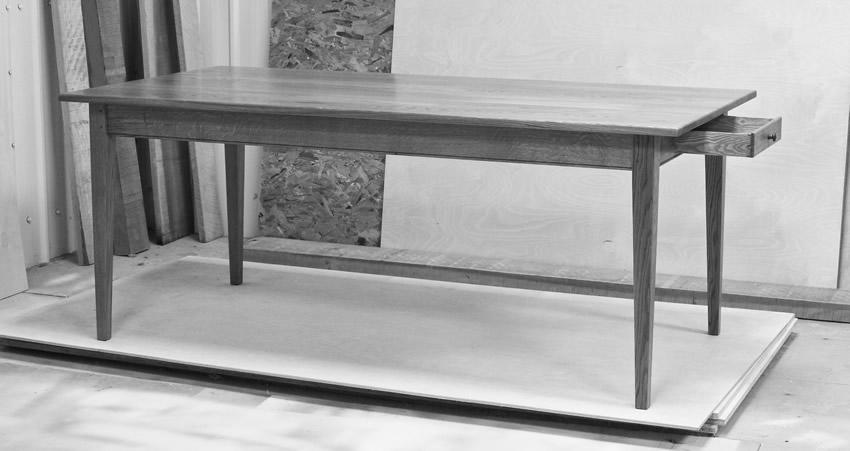 Oak Shaker style table with tapered legs and oak dovetailed drawer. The table is finished with hardwearing 'Osmo' hardwax oil. Oak Shaker style table with tapered legs and oak dovetailed drawer. The table is finished with hardwearing 'Osmo' hardwax oil.